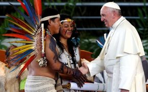 Pope Francis (R) greets members of an indigenous group from the Amazon region