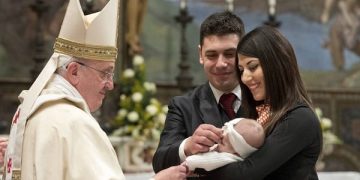 Pope Francis baptises one of 32 babies during a mass in the Sistine Chapel at the Vatican
